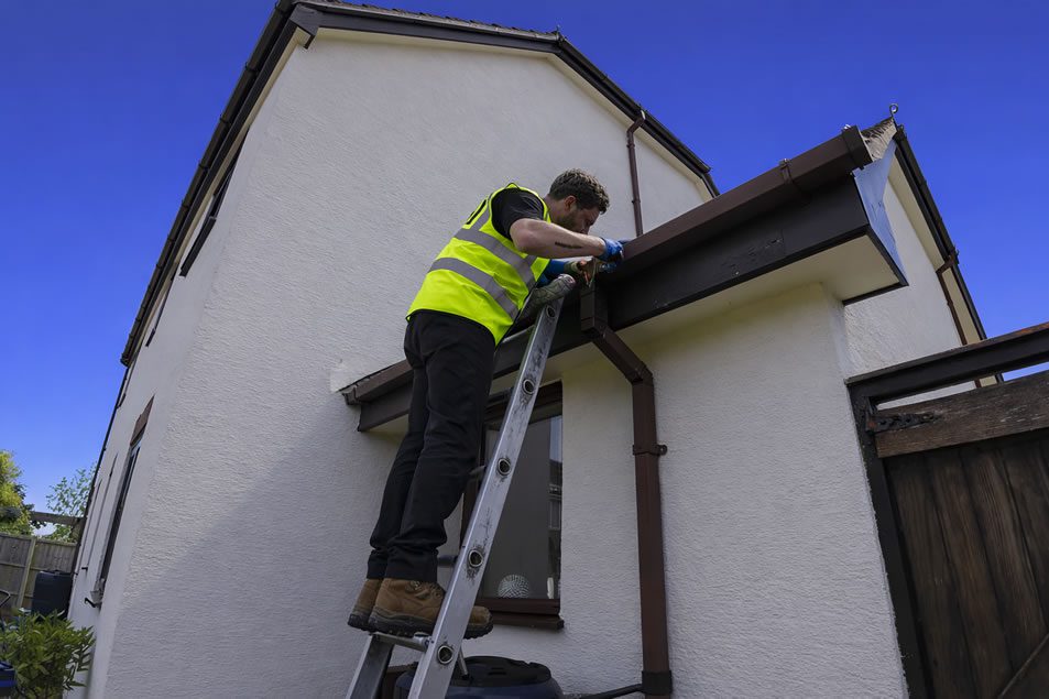 repairing gutters on a ladder